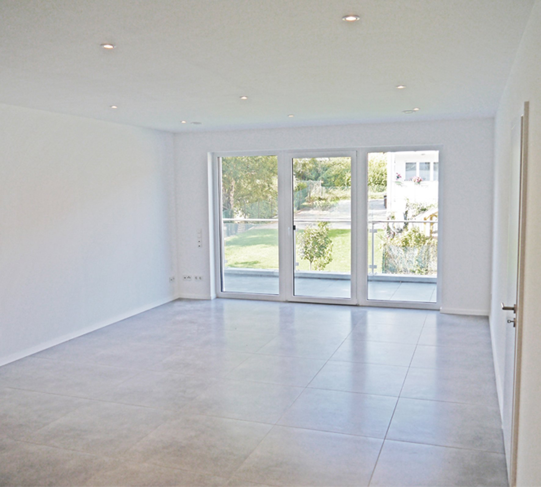 Helle, leere Wohnung mit großer Fensterfront